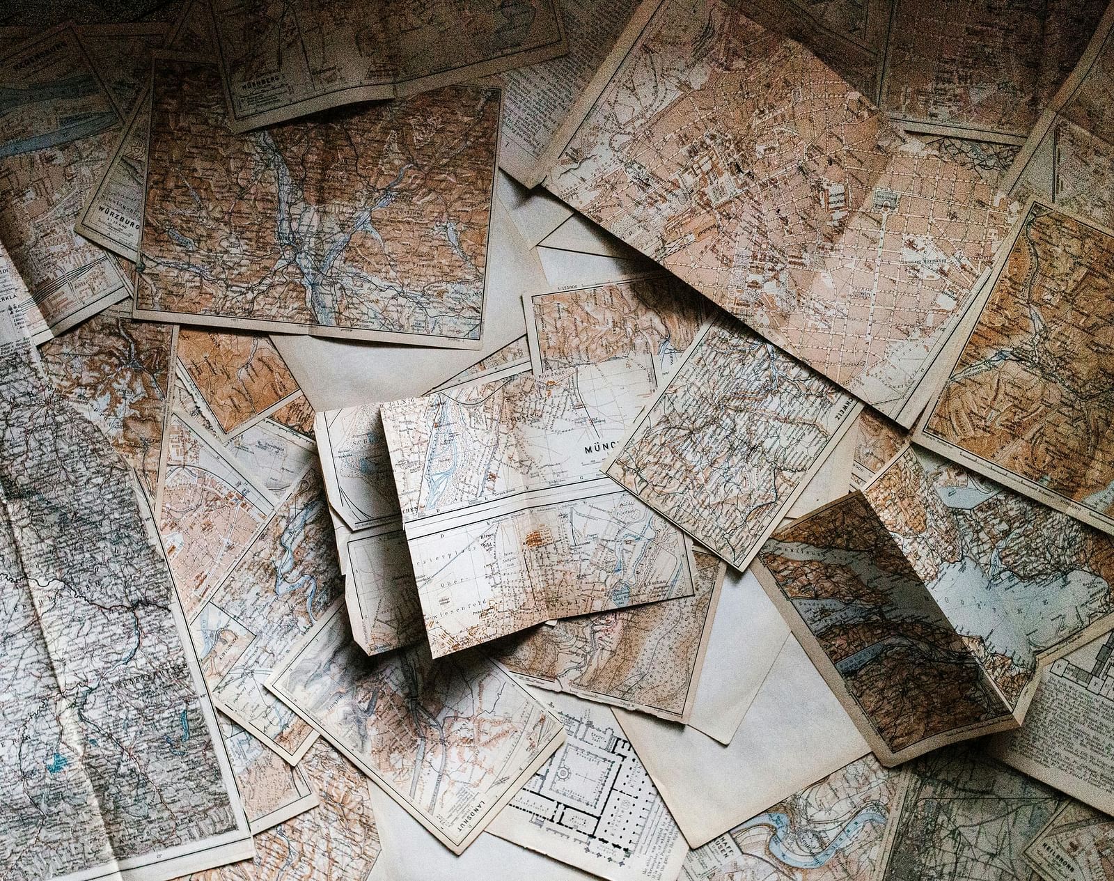 Several old texts and pages of a diary scattered on a floor.