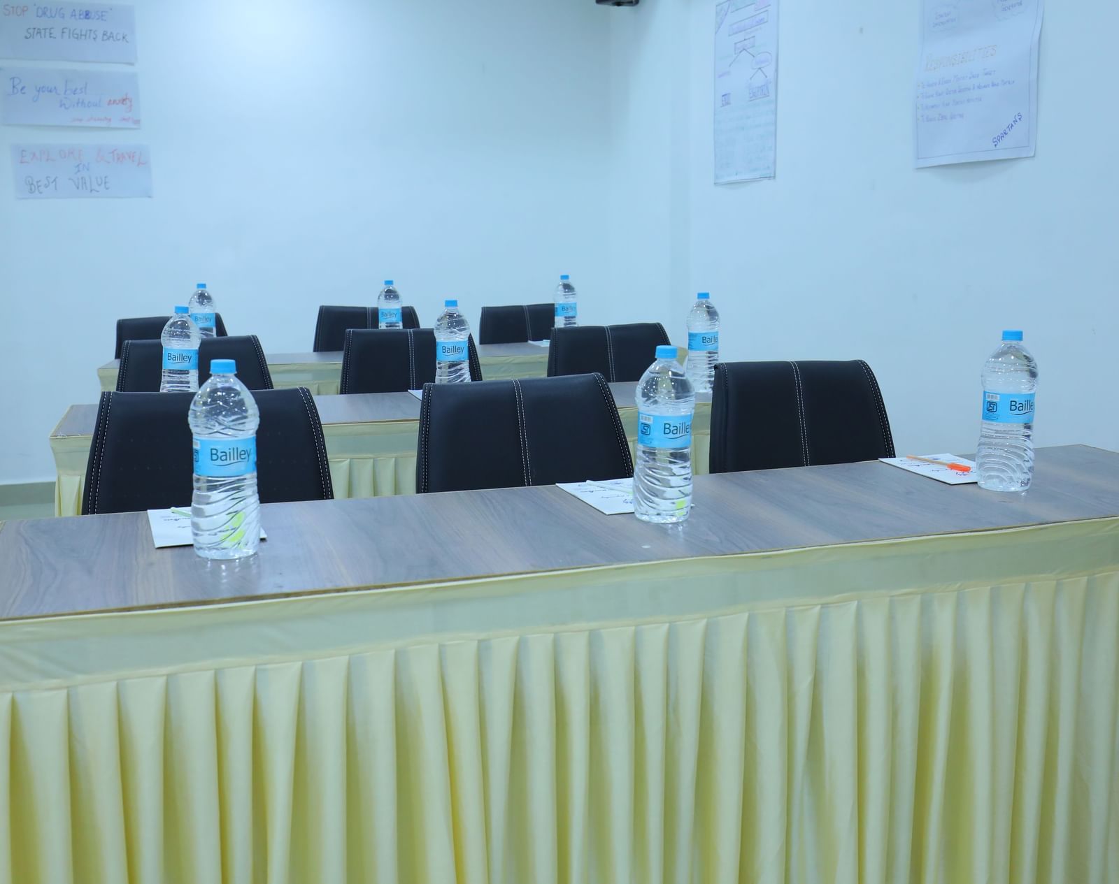 A close up of tables placed in classroom arrangement, with water bottles, stationary, in Olive banquet hall of Highland Resort.