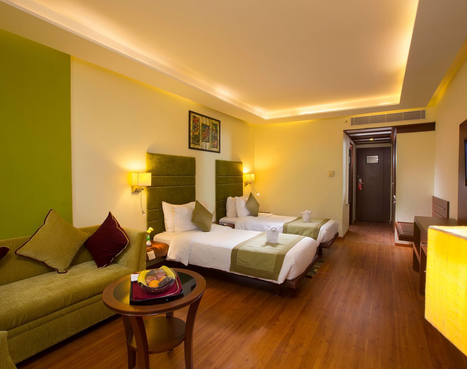 Superior Room featuring twin beds, sofa and a television at Hotel Atithi - TGI Grand, Pondicherry