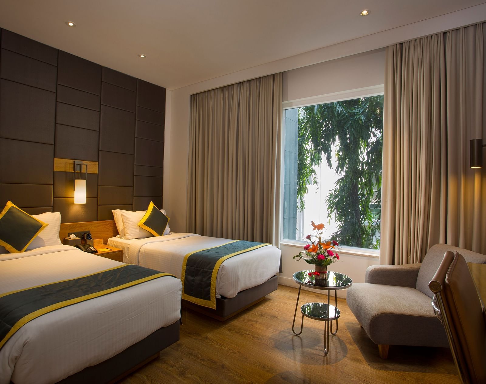 a bedroom with the curtains drawn out offering views of the city with two single beds and a sofa  - Hotel Fountain Tree By TGI - JP Nagar, Bangalore