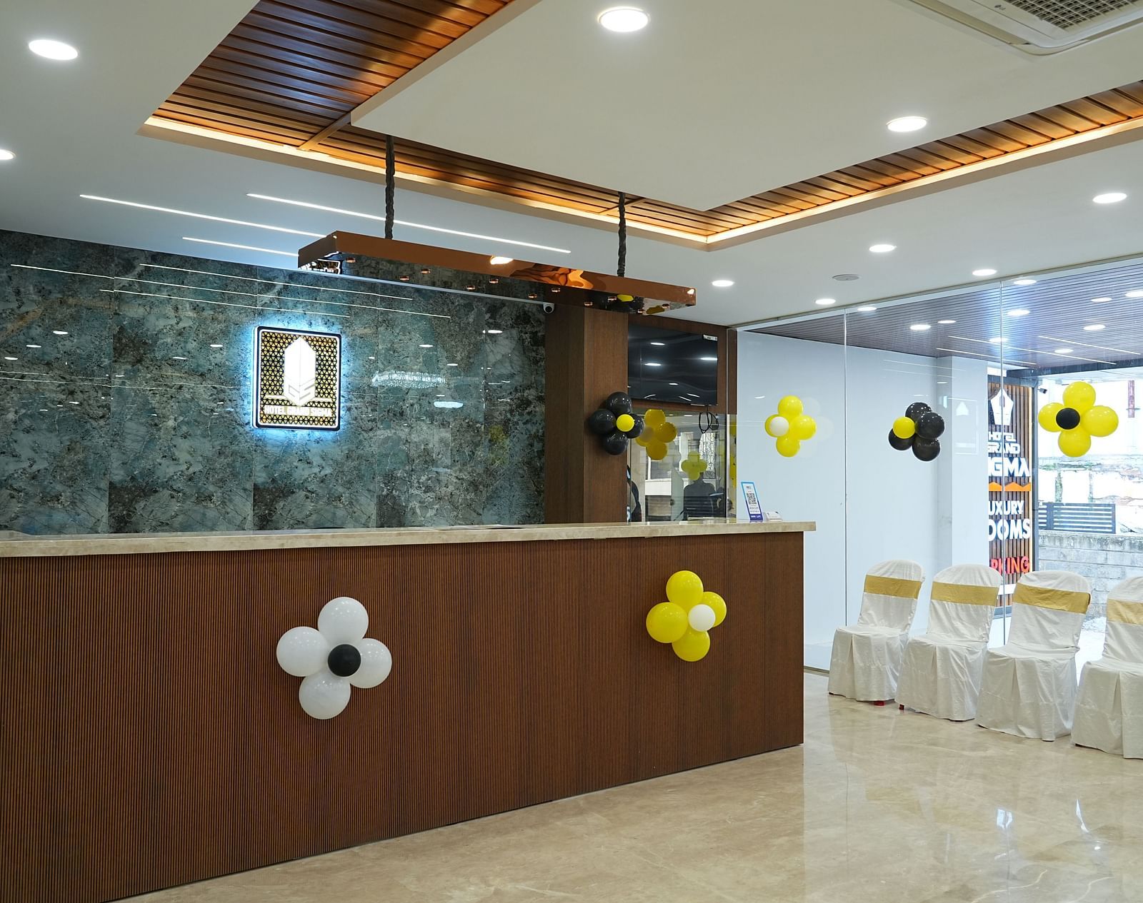 side angle view of the reception area with four chairs kept in the side - Hotel Grand Sigma