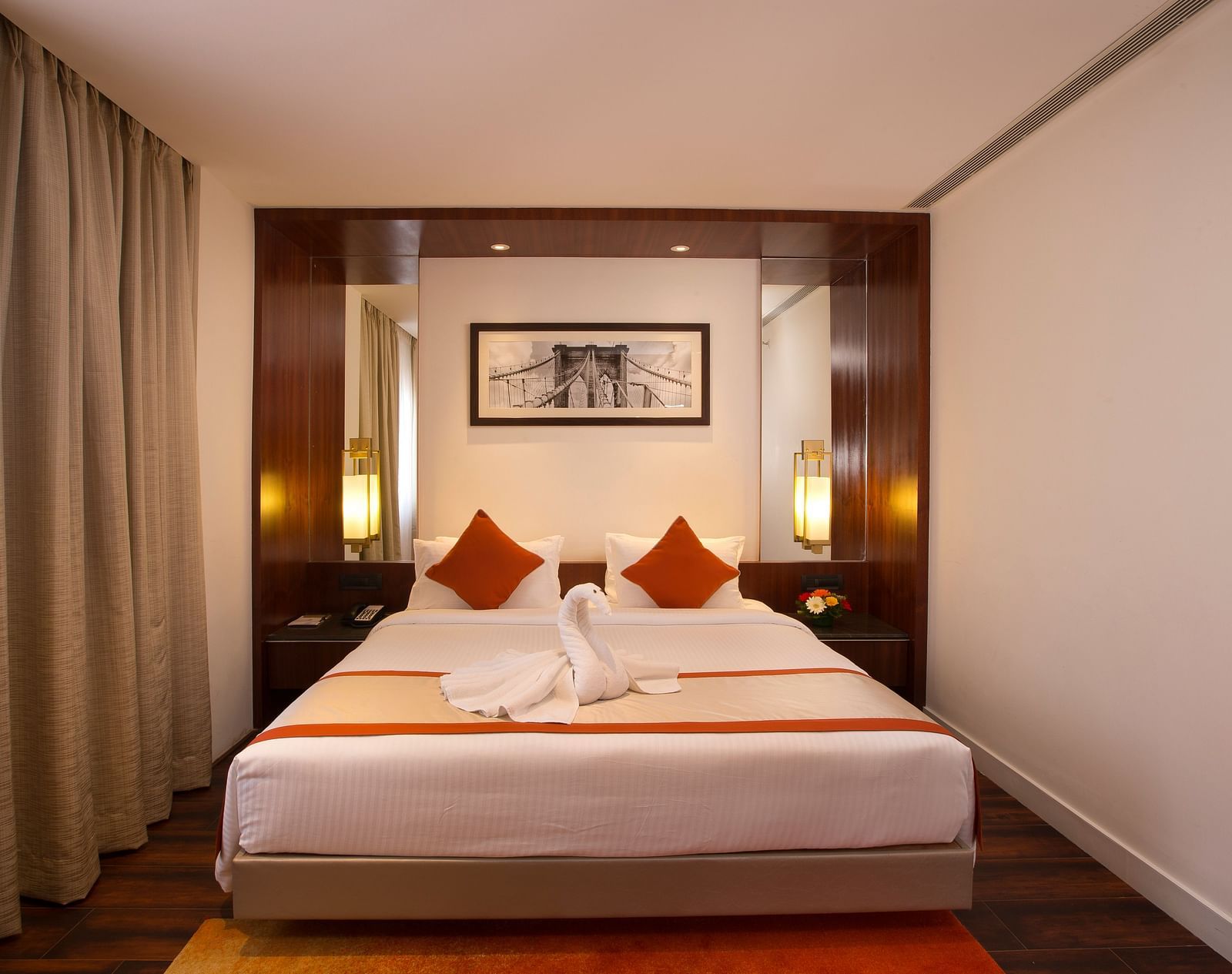 A hotel room featuring a large bed with white linens and red accents, a desk and a wall-mounted TV - Hotel Southend by TGI - Bommasandra, Bangalore