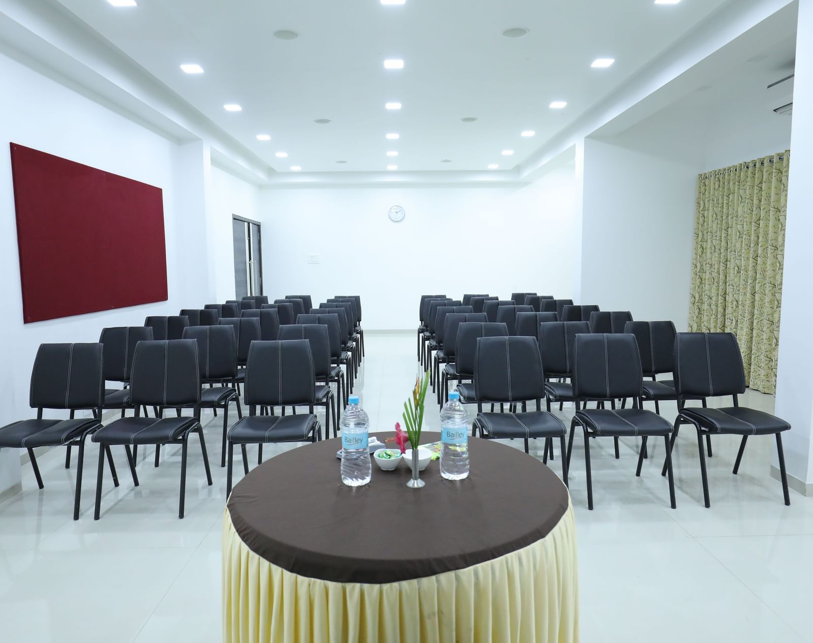 A conference room at Imperial Grande with rows of black chairs facing a small round table in the foreground.