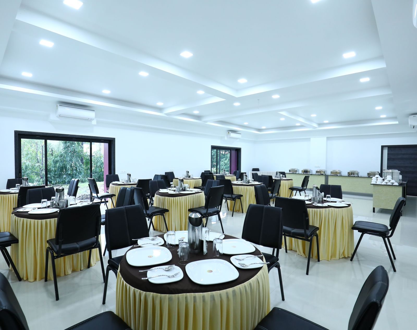 A well-lit dining space at Imperial Grande, featuring a clustered seating arrangement and windows offering a view of the outdoors.