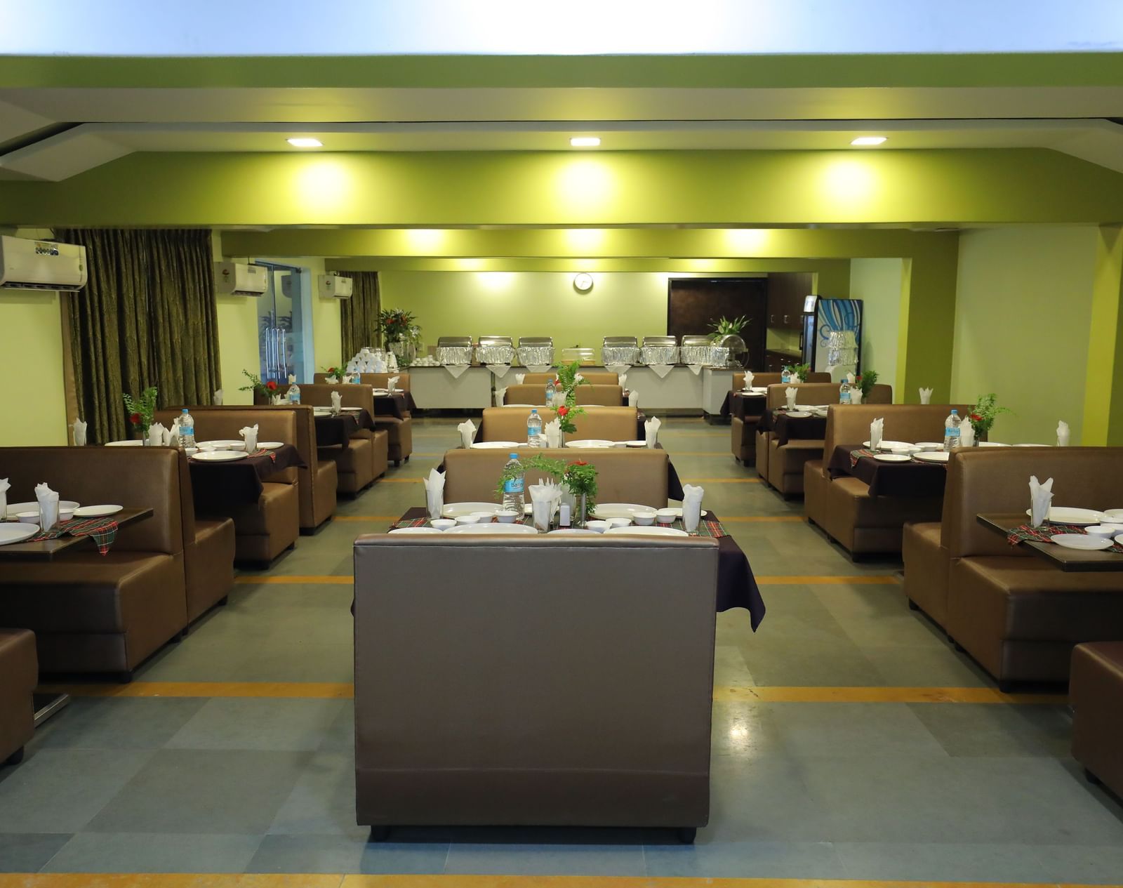 Multiple dining tables arranged in rows at Krushnai Resort restaurant.