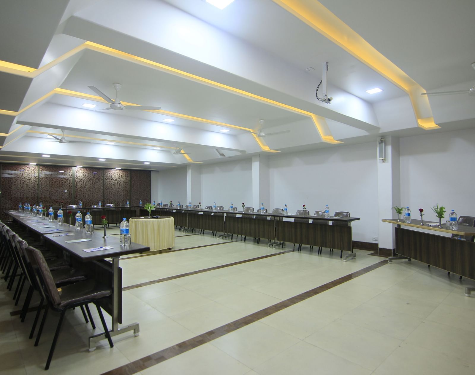 A well-lit event room at Krushnai Resort with a long table and chairs arranged for a meeting.