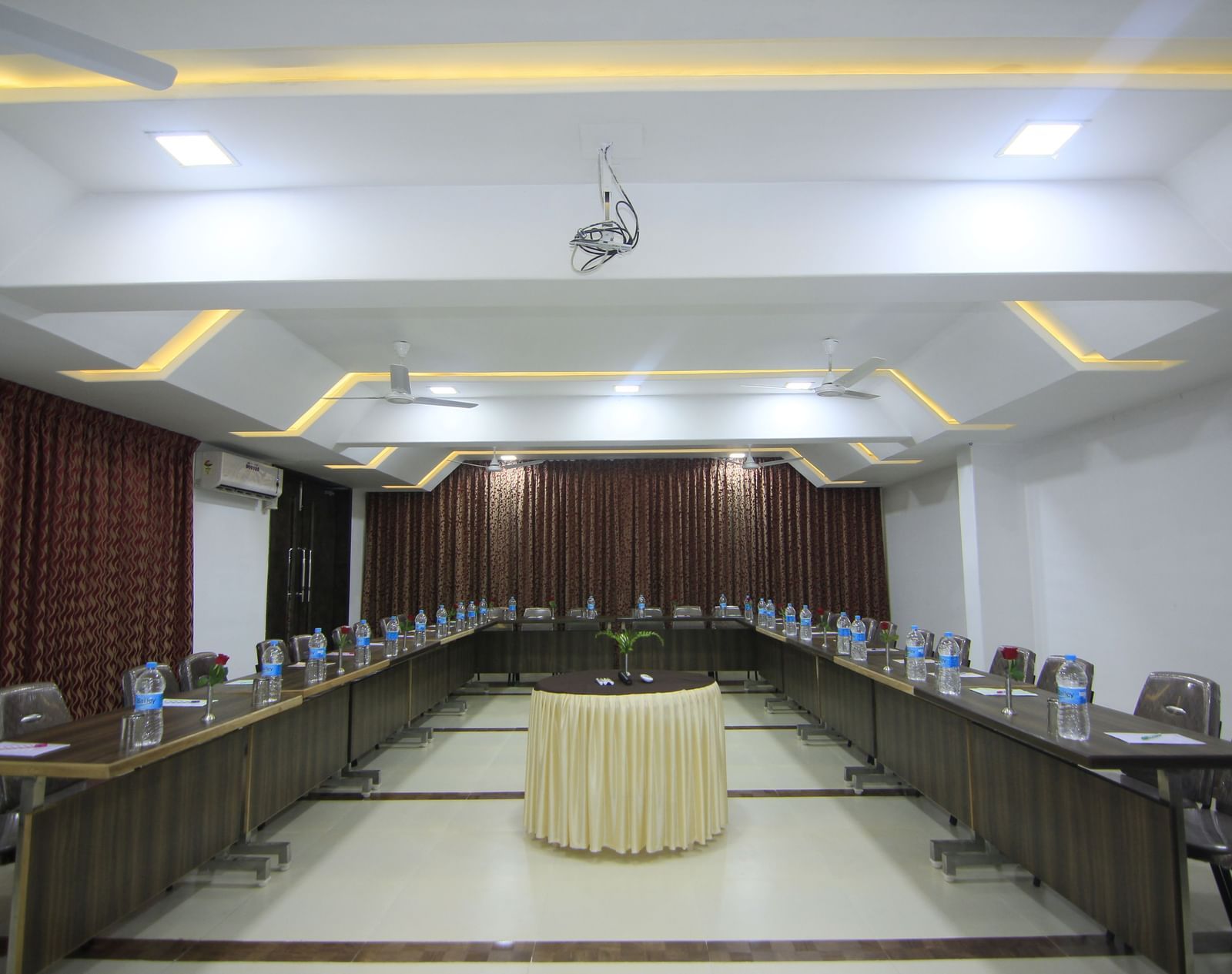 A spacious event space at Krushnai Resort with chairs and tables arranged for a conference.