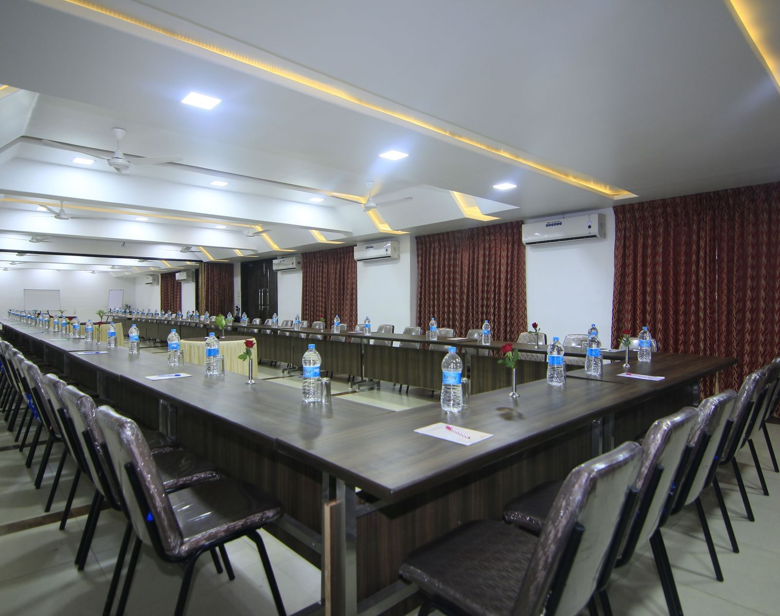 A meeting room at Krushnai Resort with a central long table surrounded by chairs in a conference arrangement, and complemented by multiple air-conditioners.