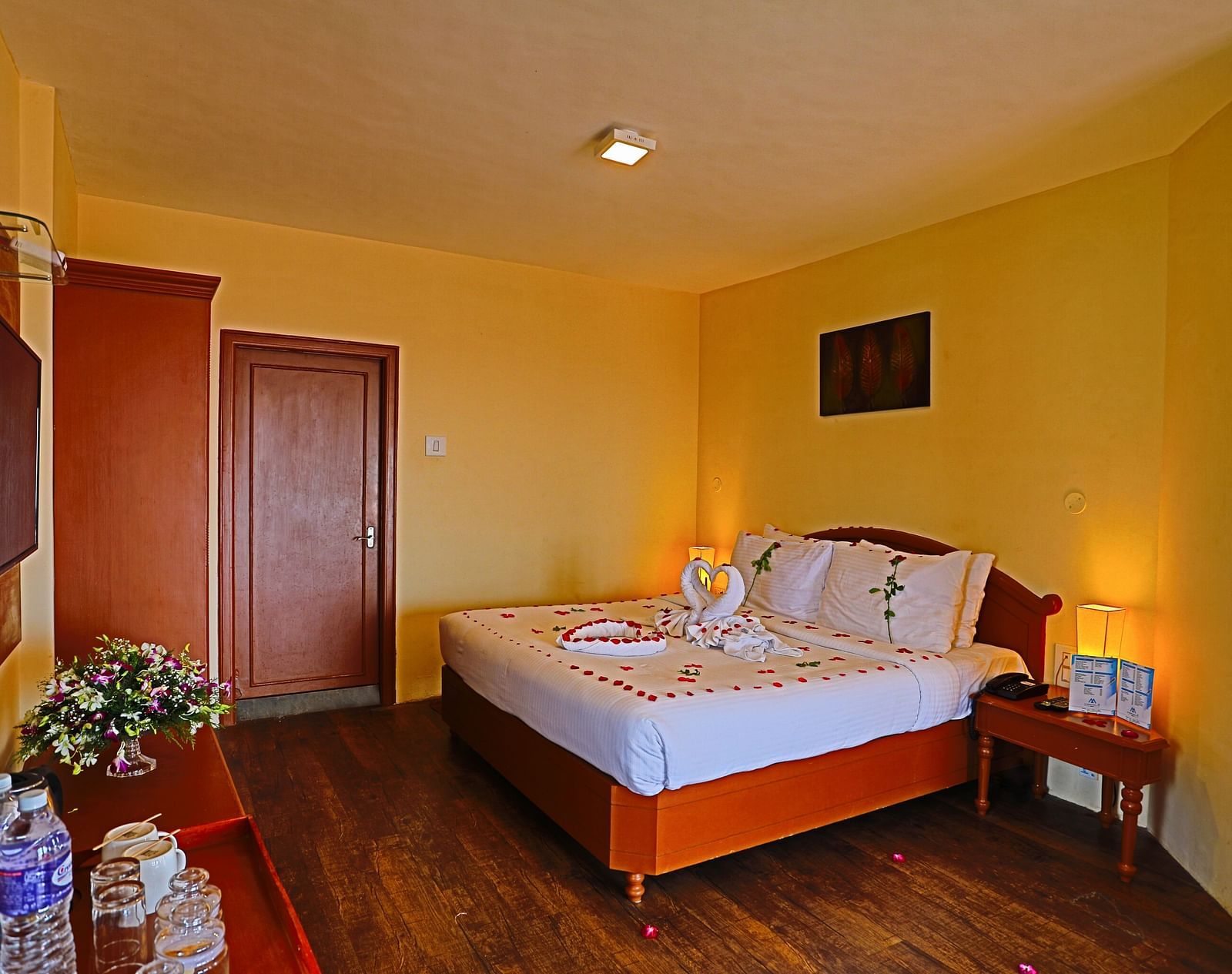 a plush white bed decked with flower petals at La Montana By TGI, Ooty