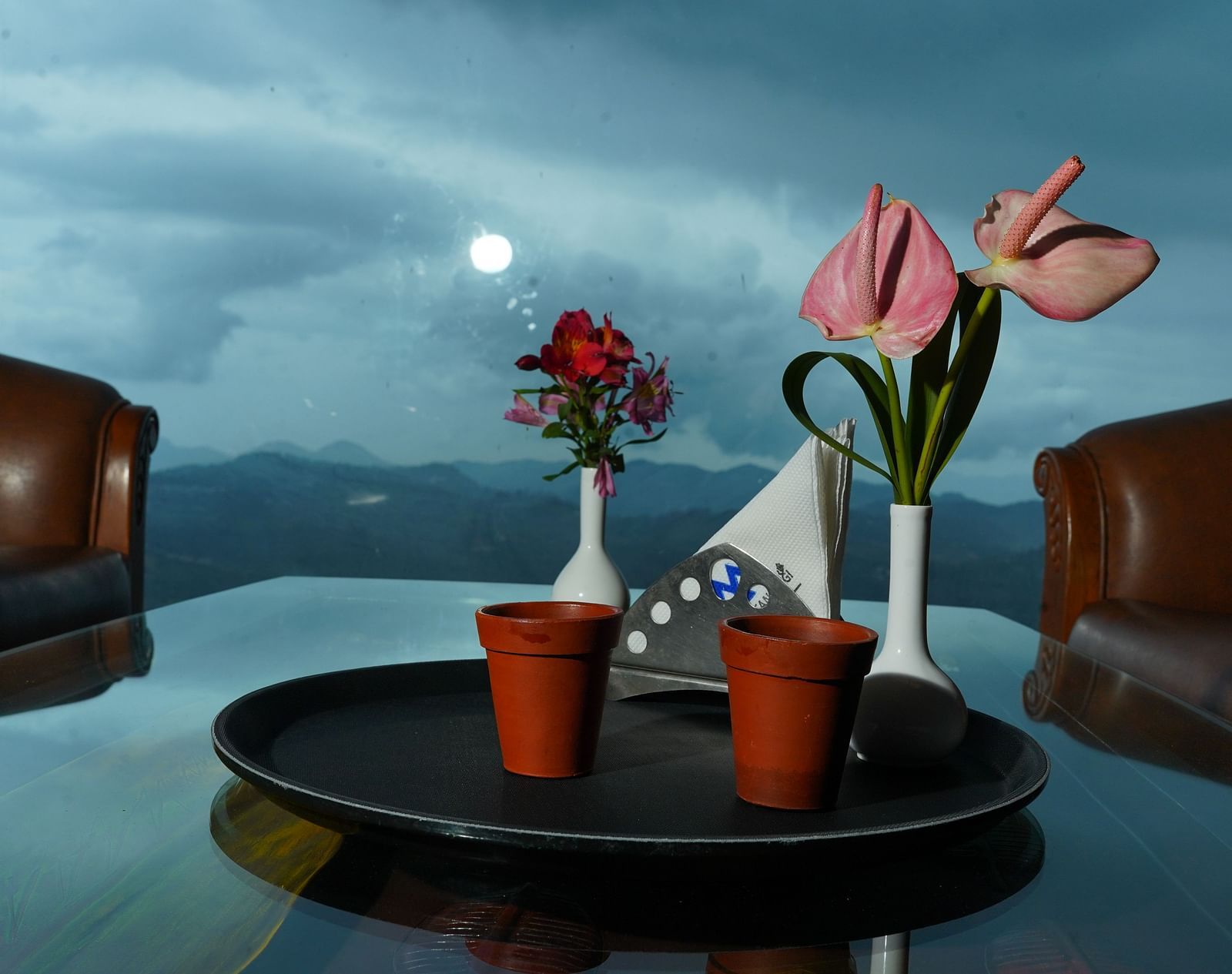 two cups of tea placed on a table along with flowers and napkins at La Montana By TGI, Ooty