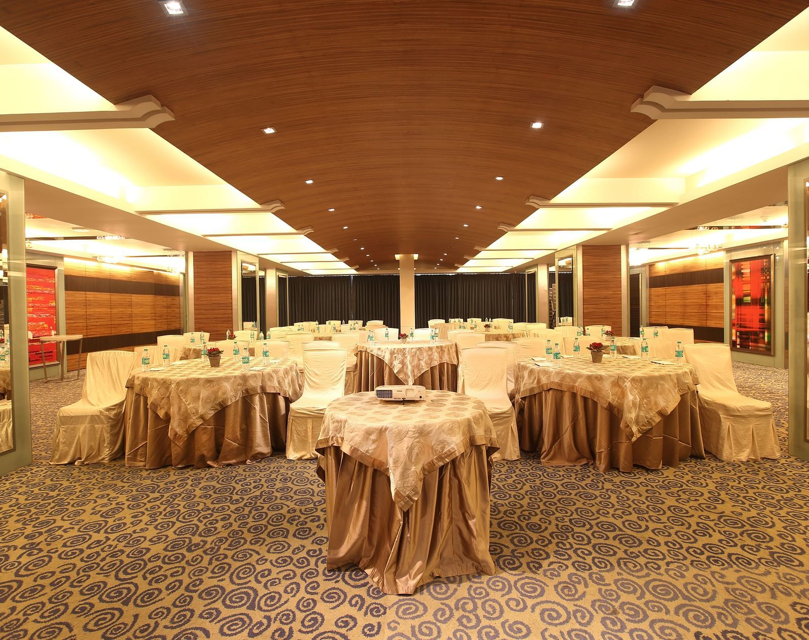 Image of Amber hall at Mirage featuring a stylish decor with brown round tables and chairs | Mirage Hotel