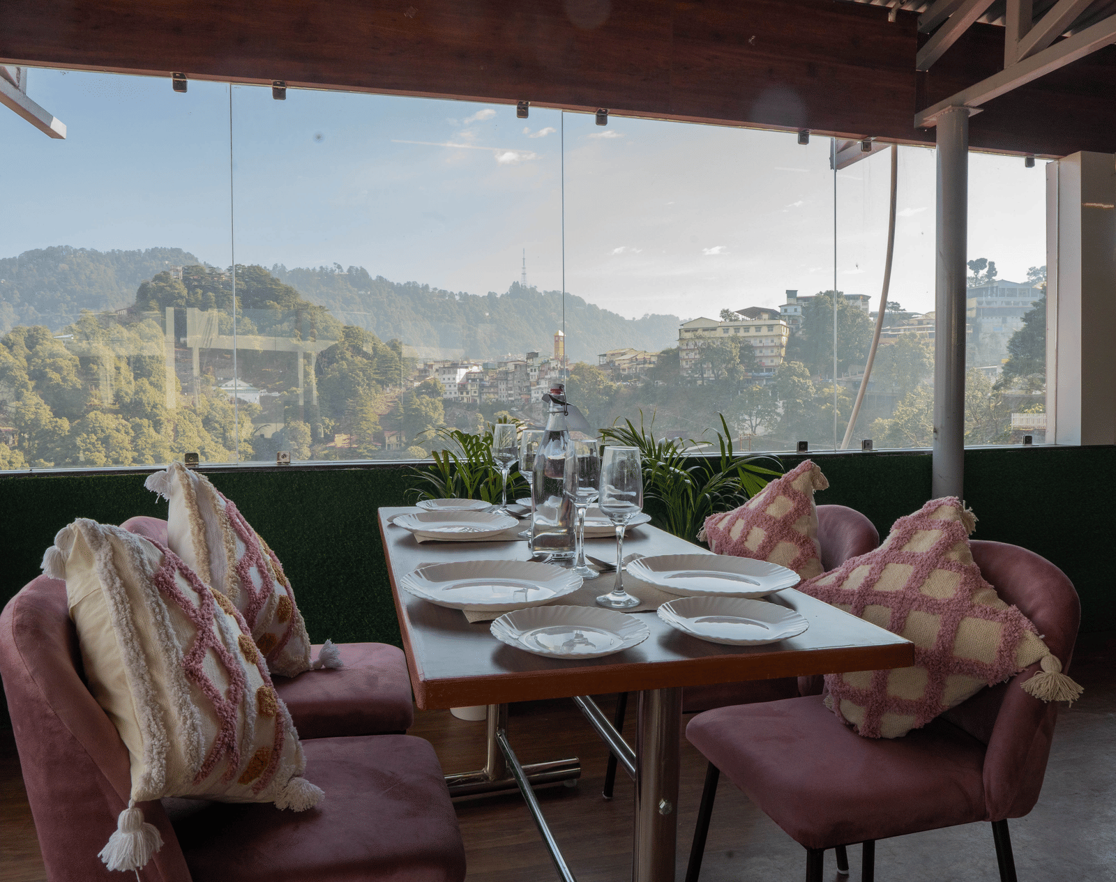 A dining area with tables and chairs overlooking mountains at Perfectstayz Premium at Mall Road Hotel Super, Mussoorie.