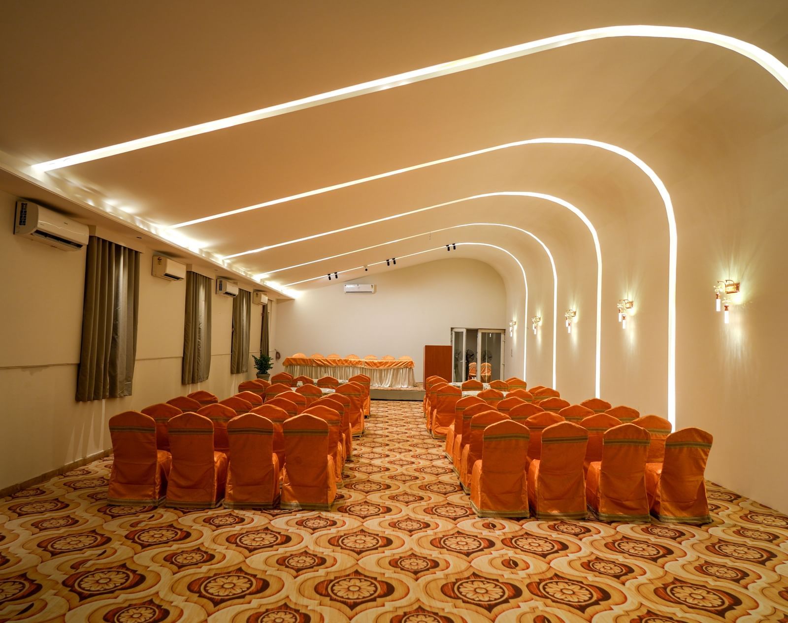 Modern banquet hall with elegant seating and ambient lighting at Pravasa Hotel Kolhapur.