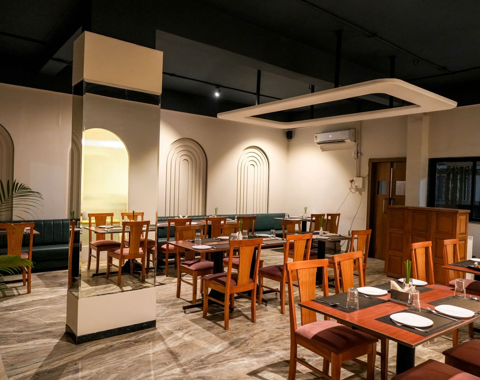 Modern restaurant with chic decor and wooden furnishings at Pravasa Hotel Kolhapur.