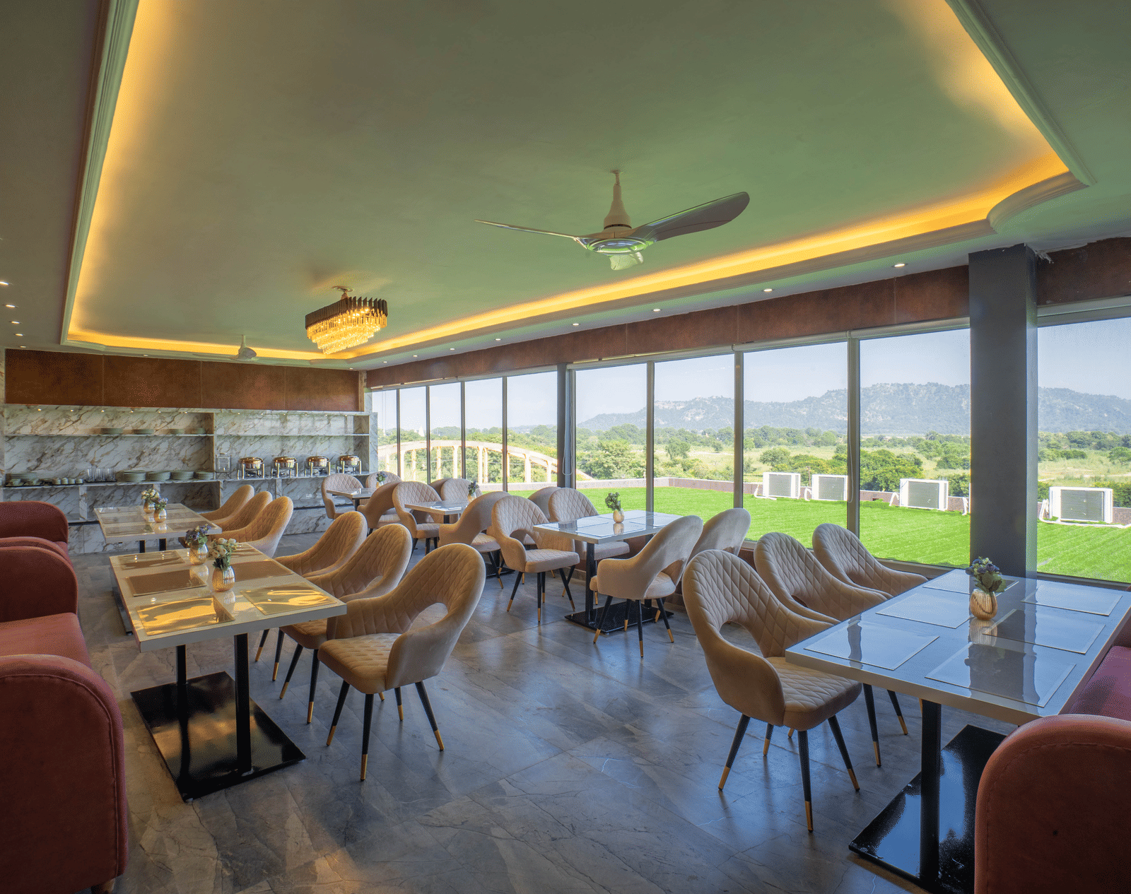 The bright, modern dining area at Sukoon by the Ganges features floor-to-ceiling windows with lovely outdoor views.
