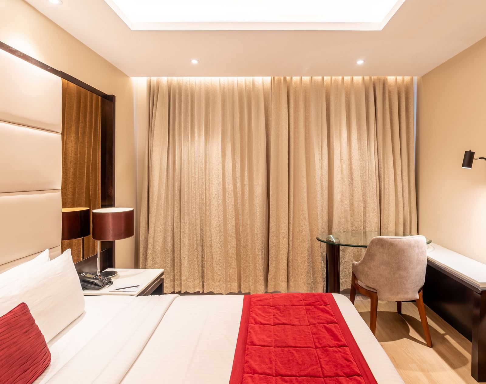 Fortuna suite's room featuring a large bed, curtains, and work desk- TGI Grand Fortuna, Krishnagiri Main Road, Hosur