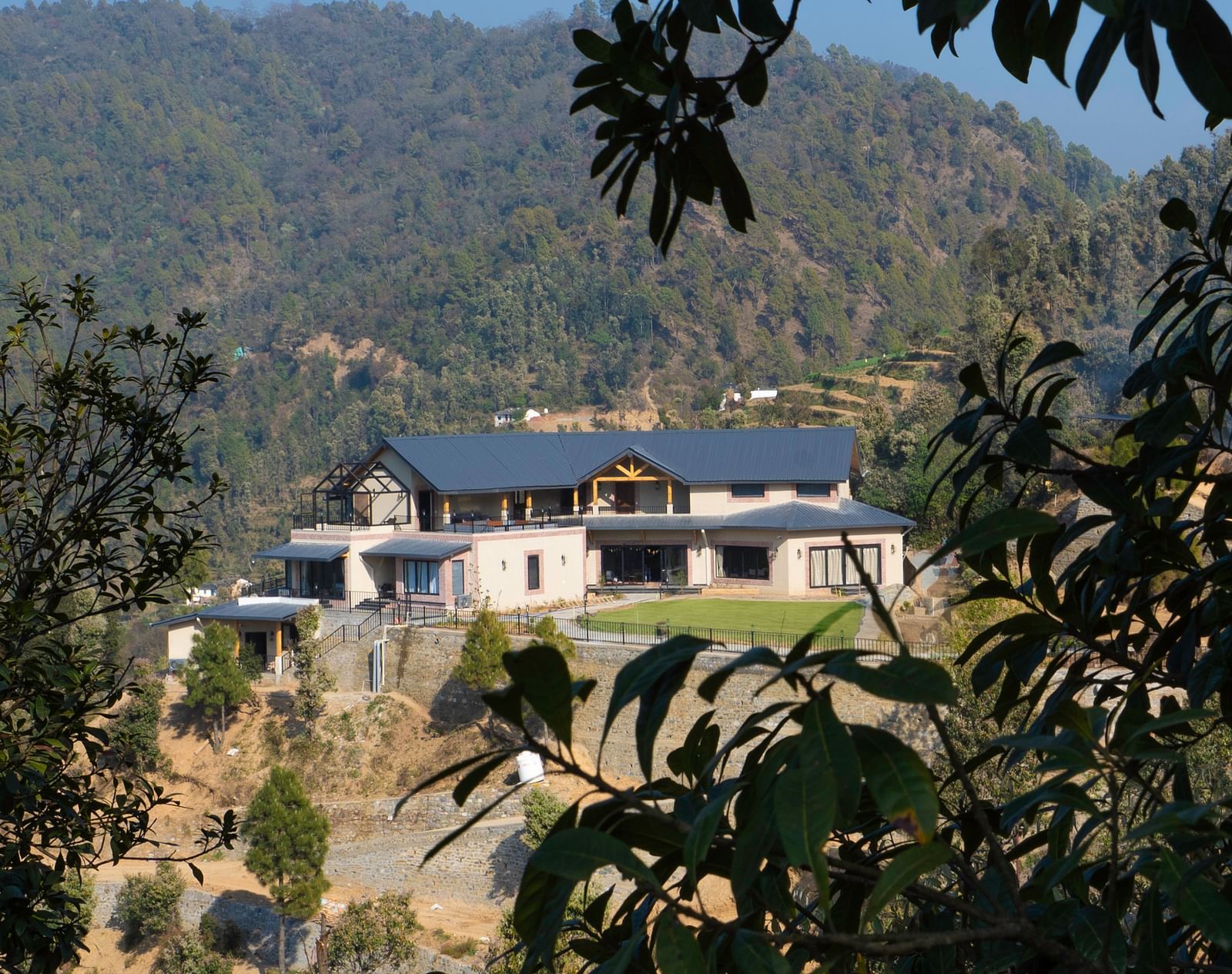 View of The Chamomile Estate facade nestled in a lush hillside landscape.