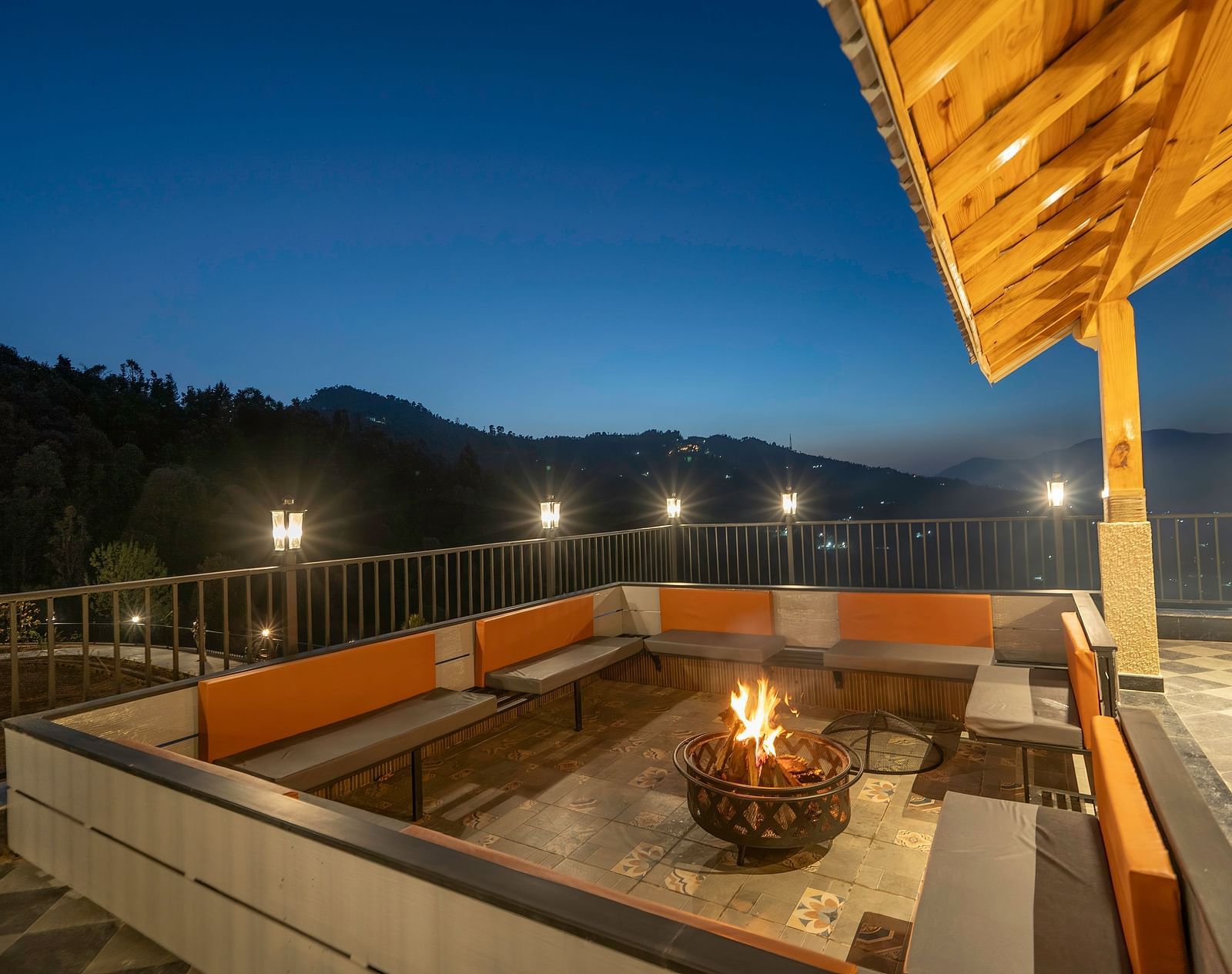 Balcony view at night with a firelight in the centre, surrounded by a seating area at The Chamomile Estate.