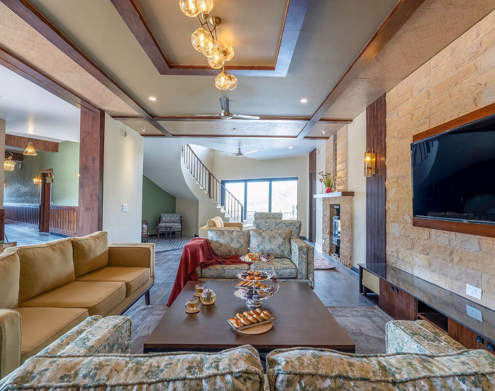 View of a stylish living room, featuring furniture arranged around the table and a wall-mounted television at The Chamomile Estate.