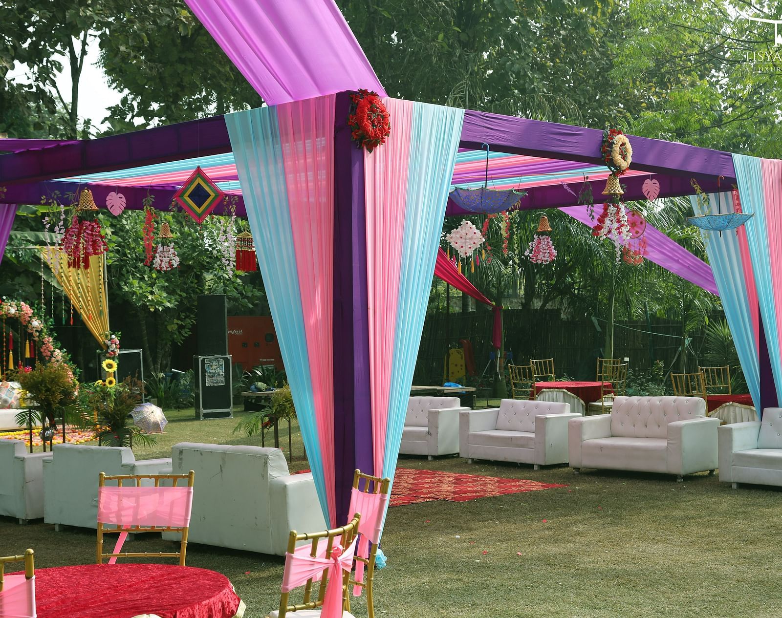 Lounge seating under pink and purple fabric canopy at Tisya Farms, Gurgaon.