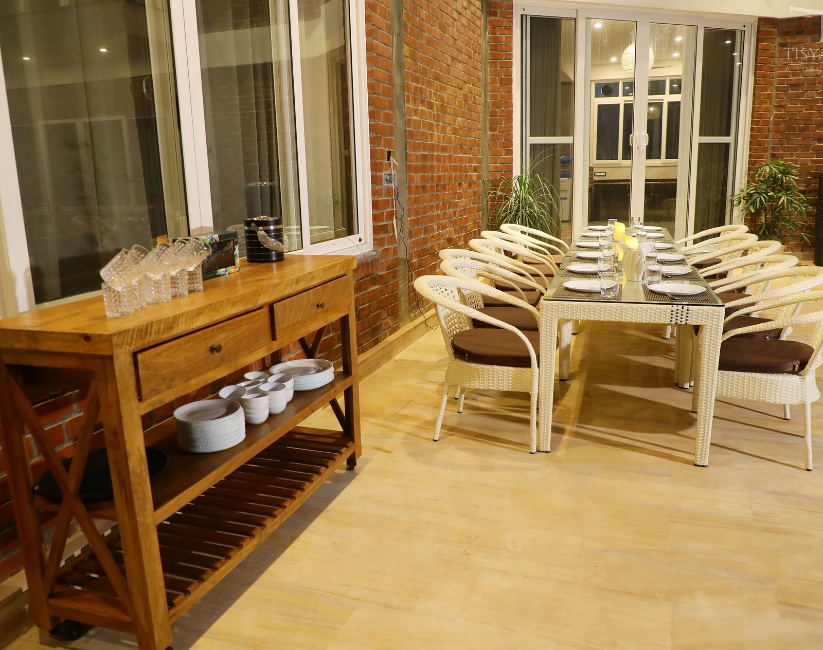 A dining table with cutlery and plates set for a meal at Tisya Farms, Gurgaon.