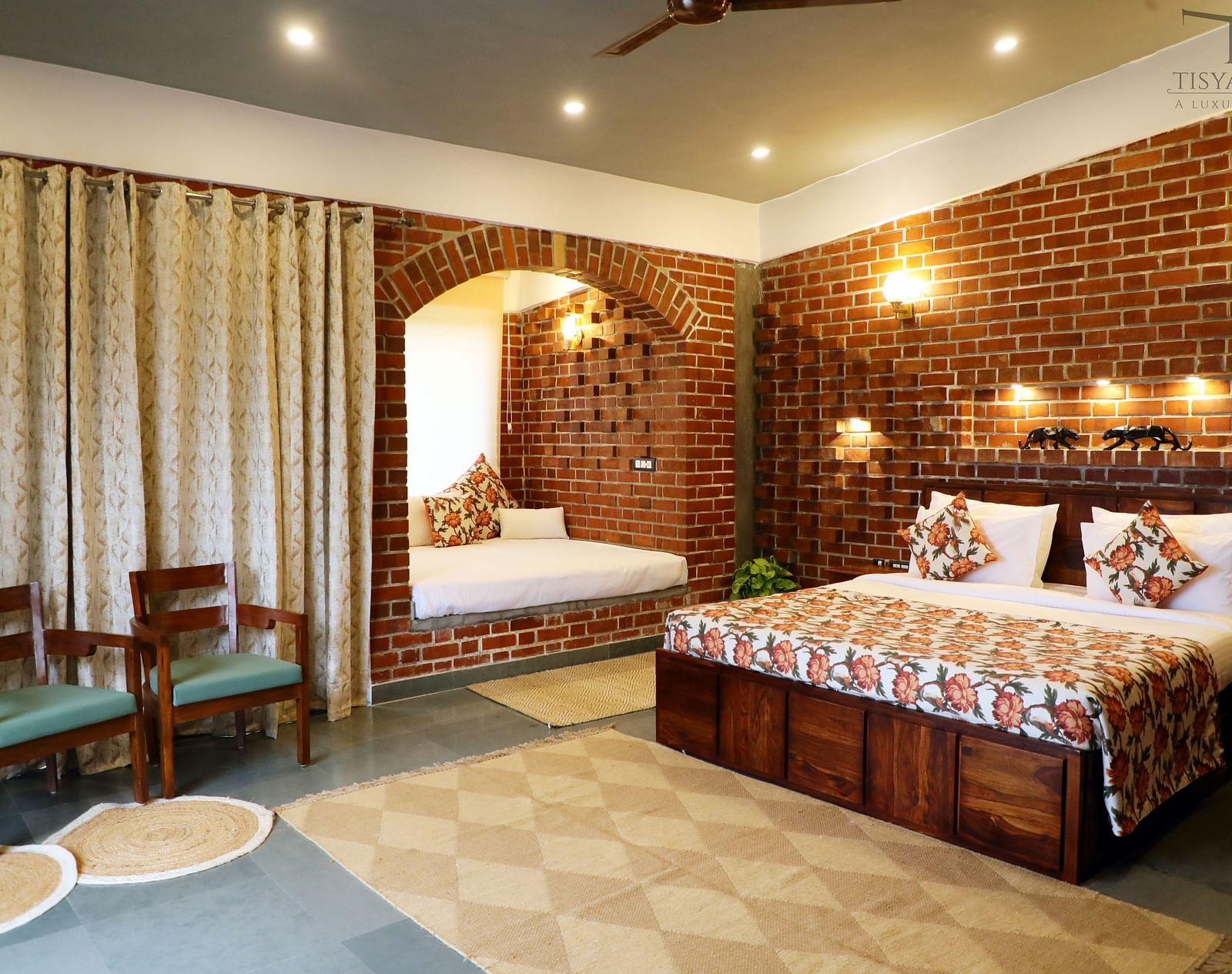 A suite featuring a king size bed with warm lighting illuminating above the bed at Tisya Farms, Gurgaon.