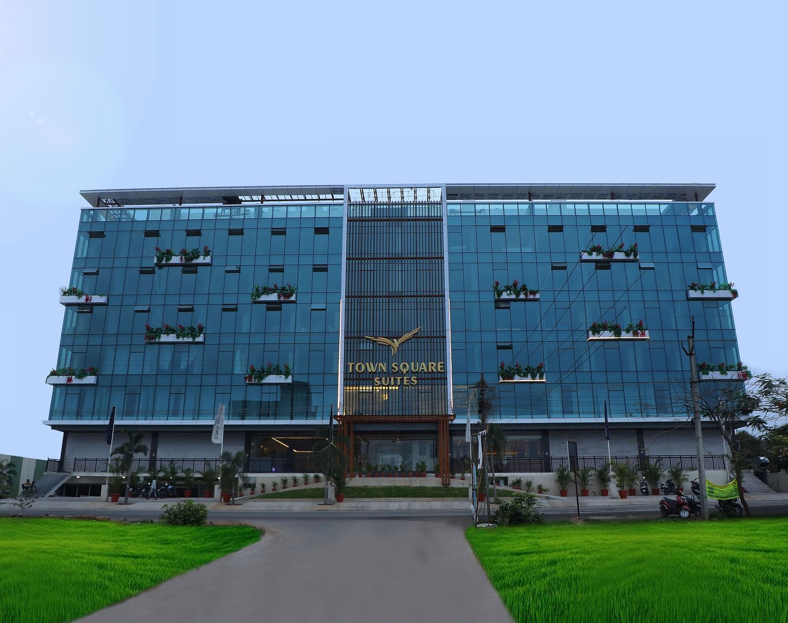 Exterior view of Town Square Suites showing modern architectural design and lush green lawn
