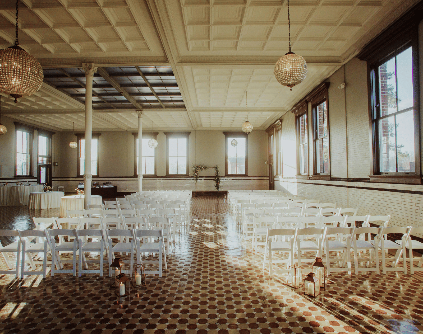 A well-lit conference room with rows of chairs arranged for a formal meeting, featuring large windows and patterned flooring.