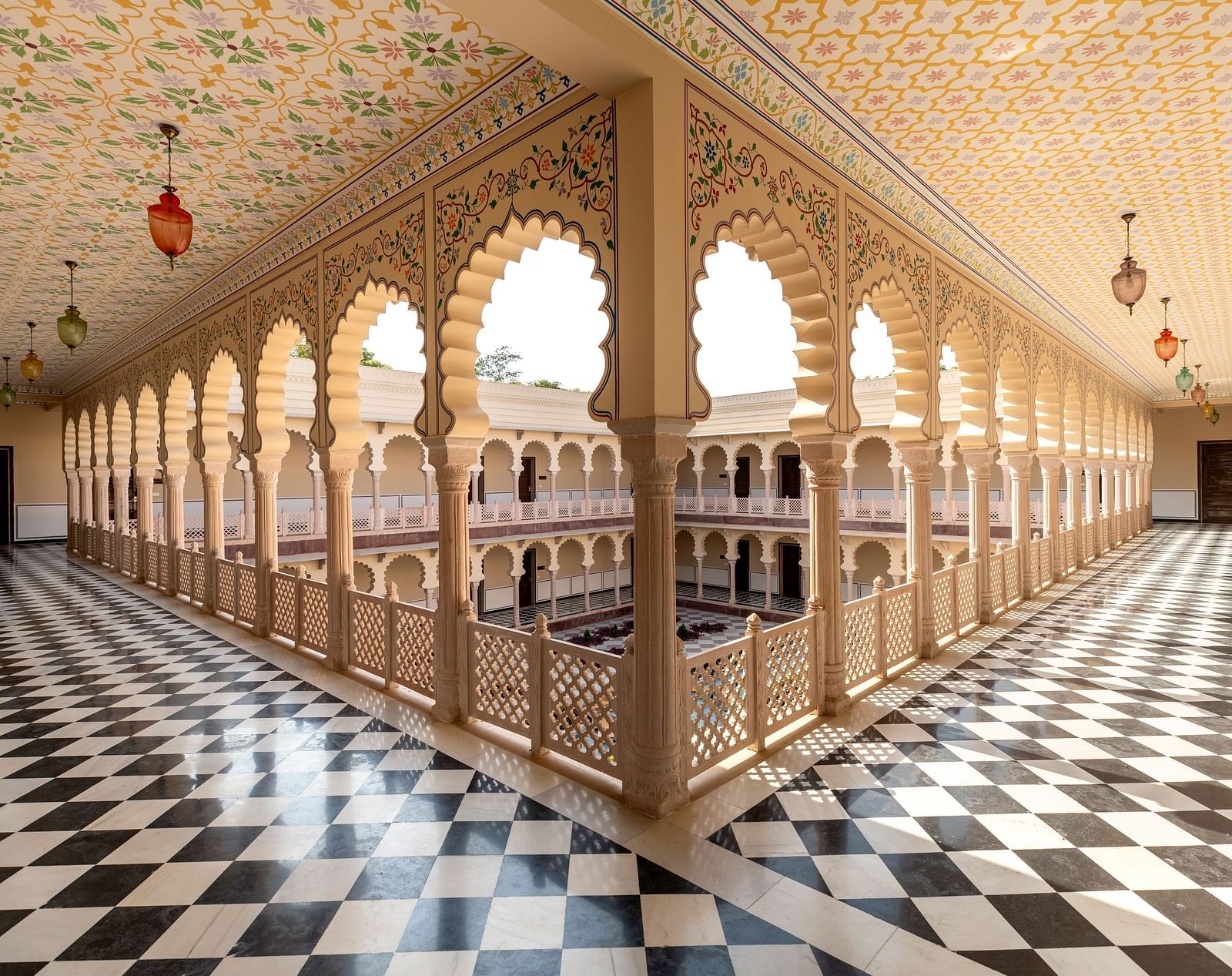 Ornate palace corridor with arches and black-and-white flooring