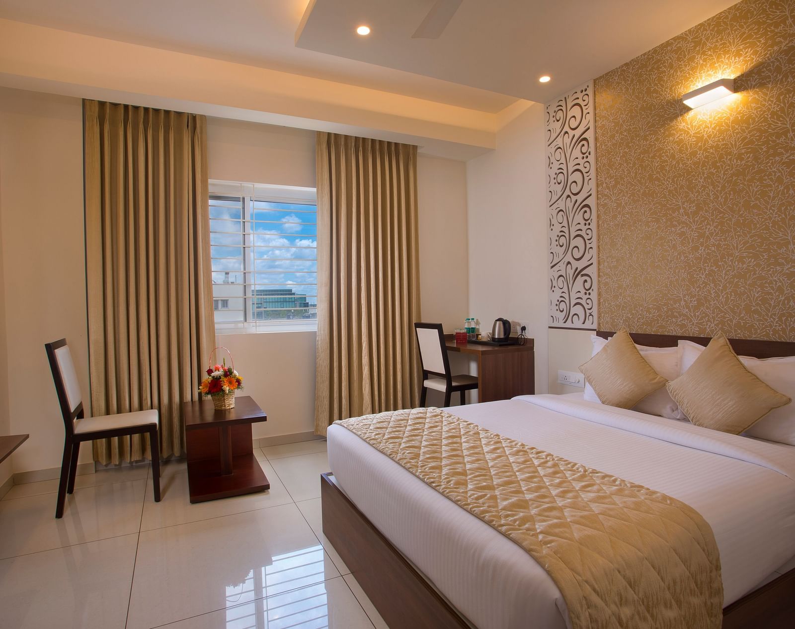A hotel room with a comfortable bed, a wooden side table with flowers and a city view through the window - De Venetian by TGI, Brookefield