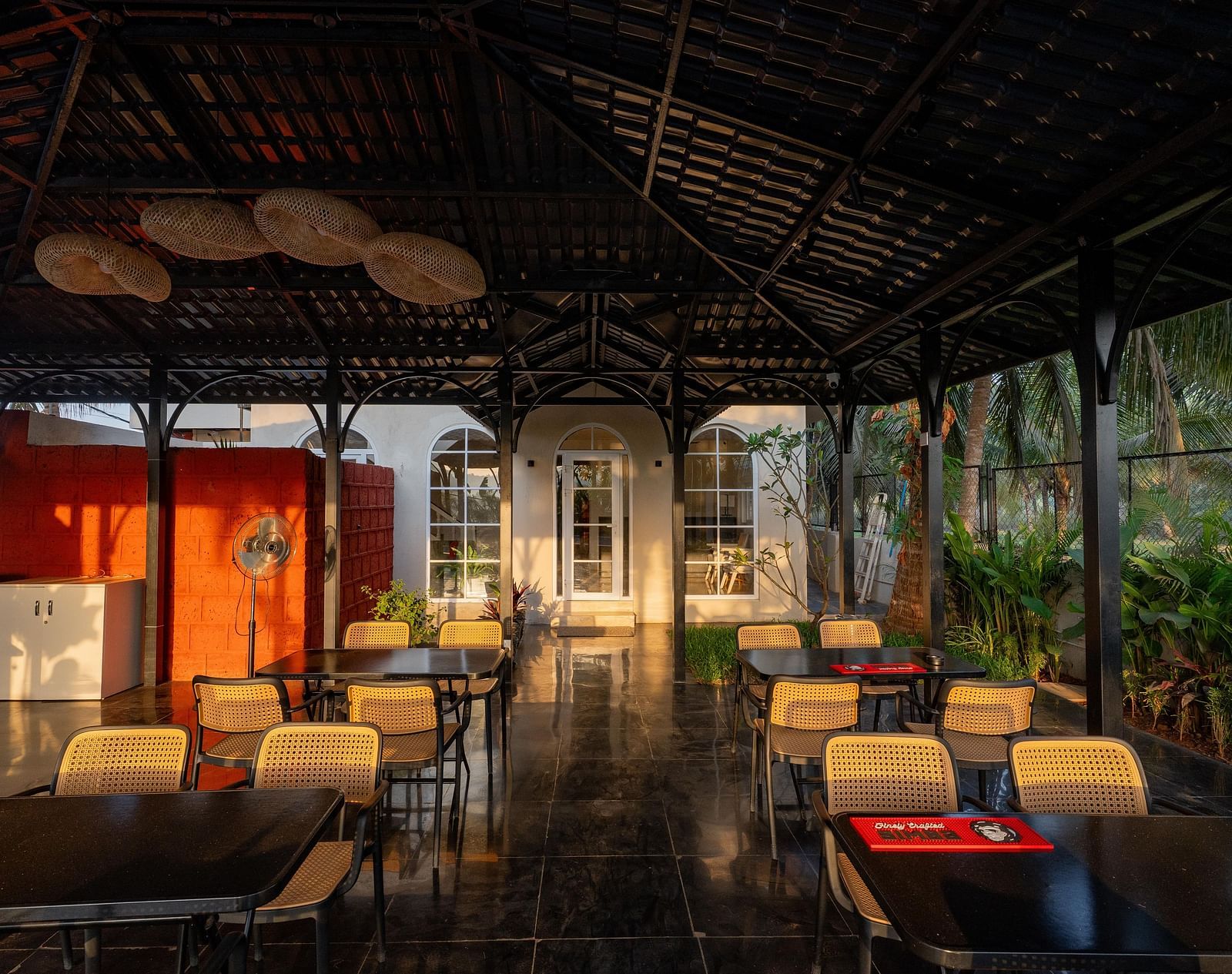 A partially enclosed outdoor dining area with a dark, peaked roof at Kssemya.