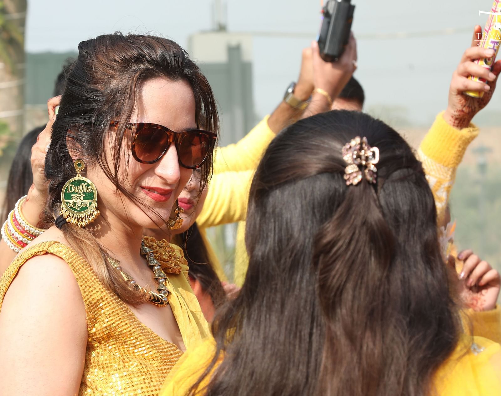 Guests in yellow attire smiling and enjoying the event at Tisya Farms, Gurgaon.