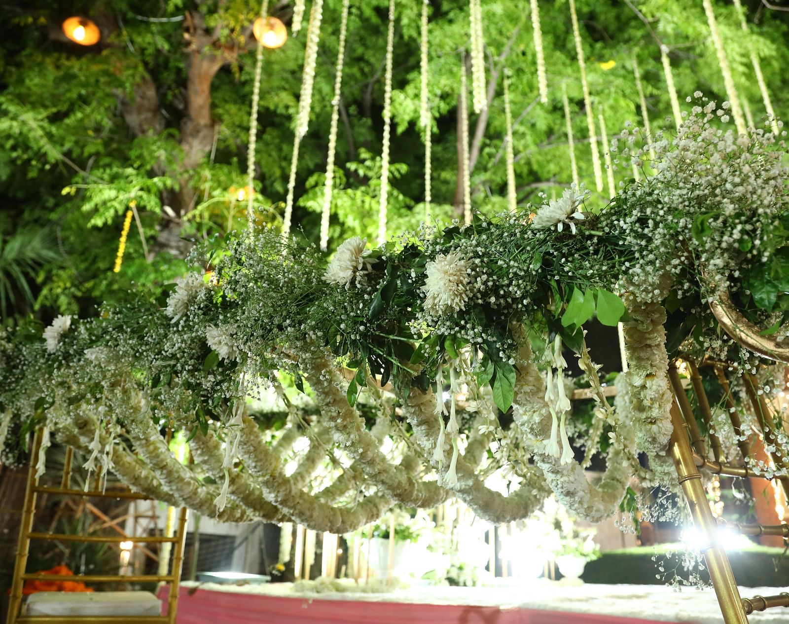 Overhead floral installation with dense greenery and hanging decor at Tisya Farms, Gurgaon.