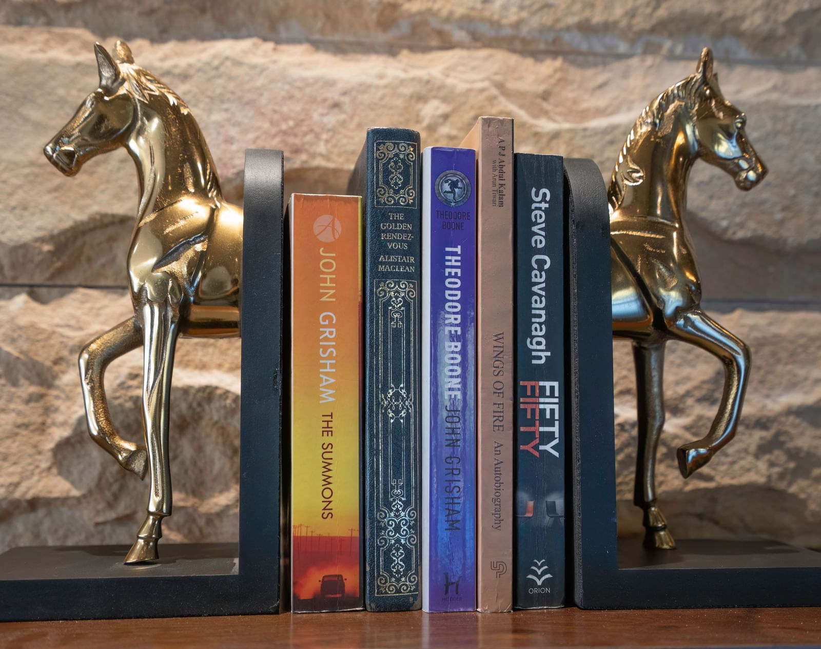 Decorative bookends shaped like horses, holding a bunch of books at The Chamomile Estate.