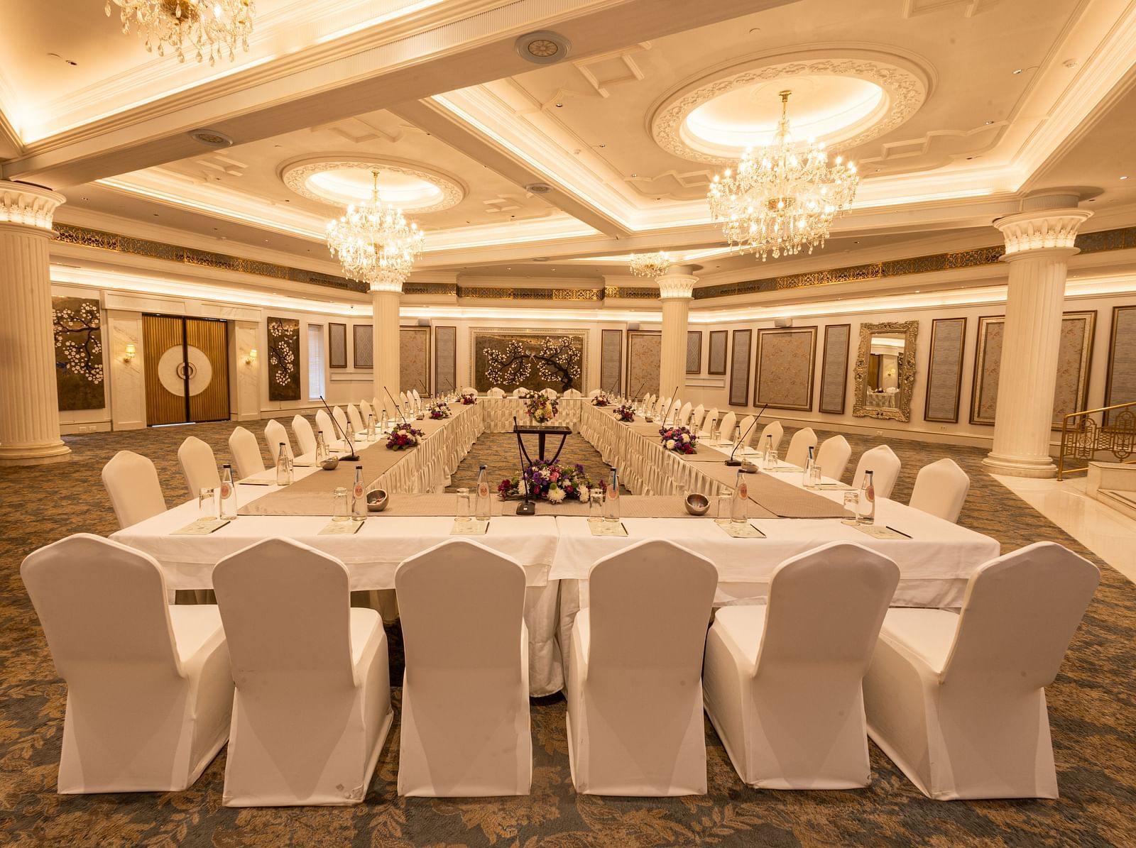 Image featuring the Viceroy Hall event venue at The Claridges New Delhi, showcasing seating arrangements and an elegant chandelier hanging overhead