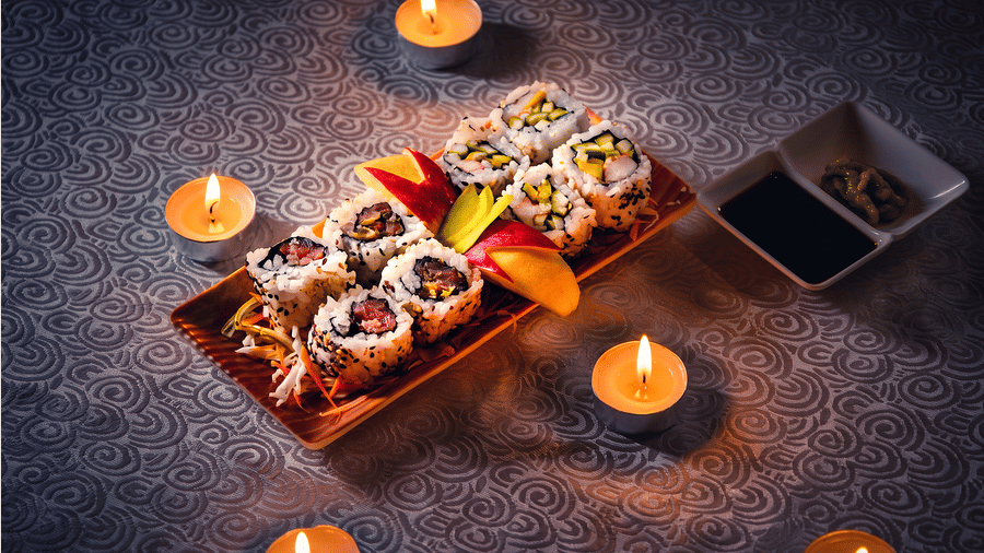 Sushi platter with assorted rolls garnished with fruit, served on a wooden tray with soy sauce and wasabi at Ajito, Ilara Hotels & Spa, Tada.
