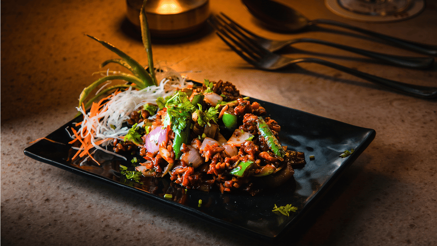 Stir-fried starter with onions, capsicum and green chillies, garnished with coriander and served by candlelight at Tandoori Tamashaa, Ilara Hotels & Spa, Tada.
