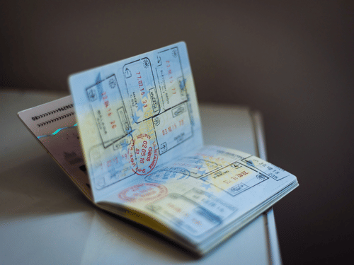 Open passport showing visa pages placed on a surface, with stamps and printed details visible inside.