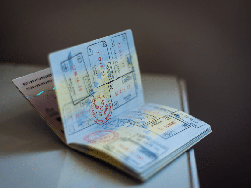 Open passport showing visa pages placed on a surface, with stamps and printed details visible inside.
