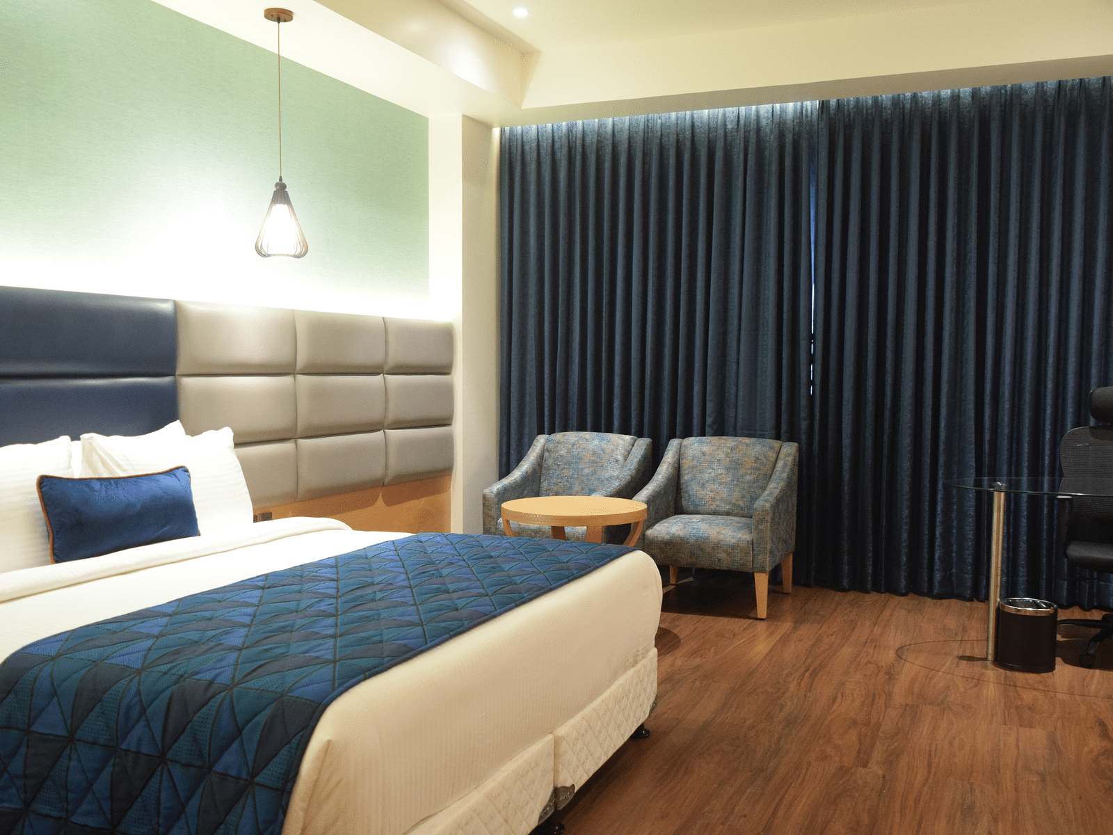 A comfy premium room with king size bed , chair at SRM Hotel Maram Malai Nagar, Chennai