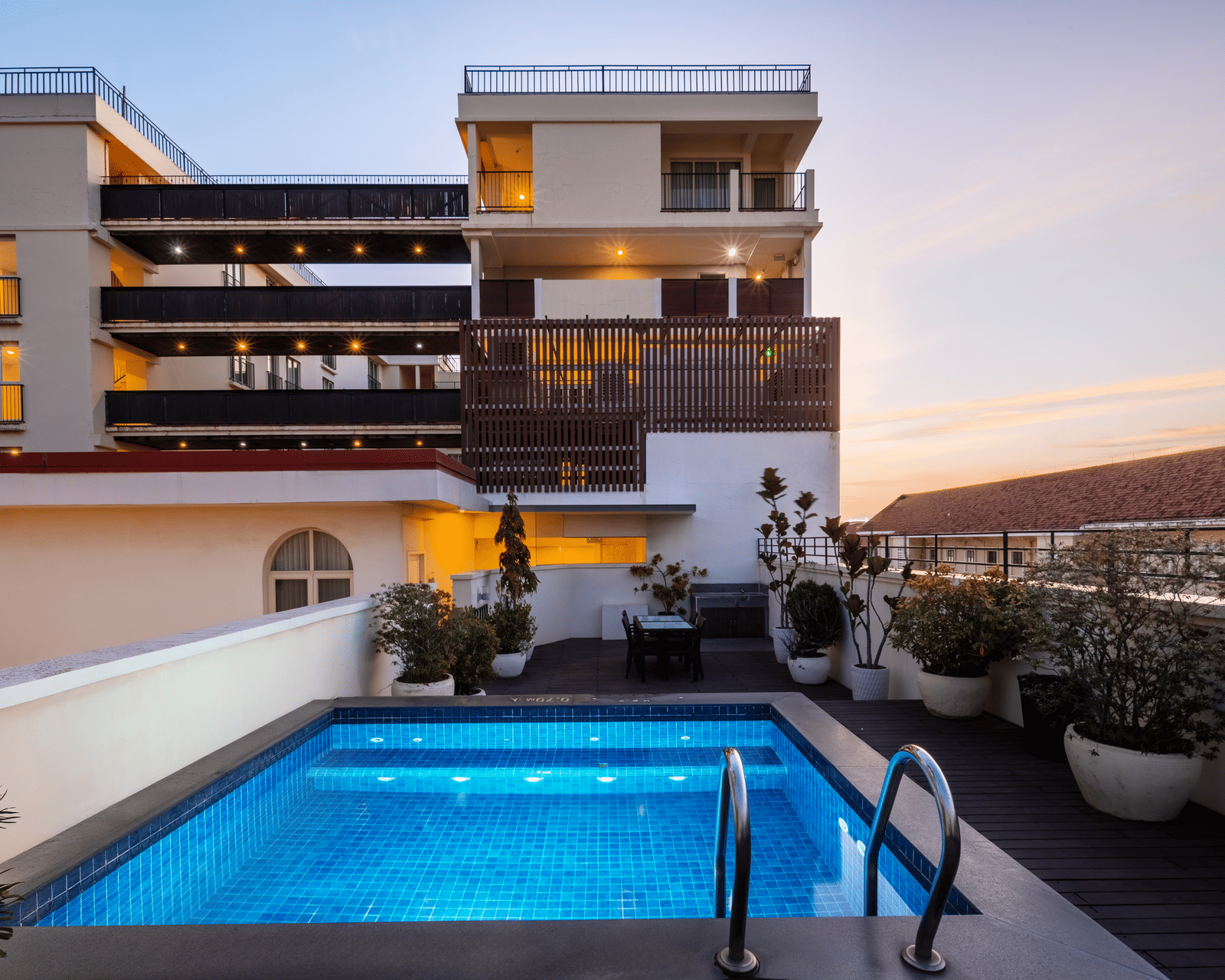 Rooftop swimming pool with lounge seating and views of the surrounding city at Central Mansions, Phnom Penh.