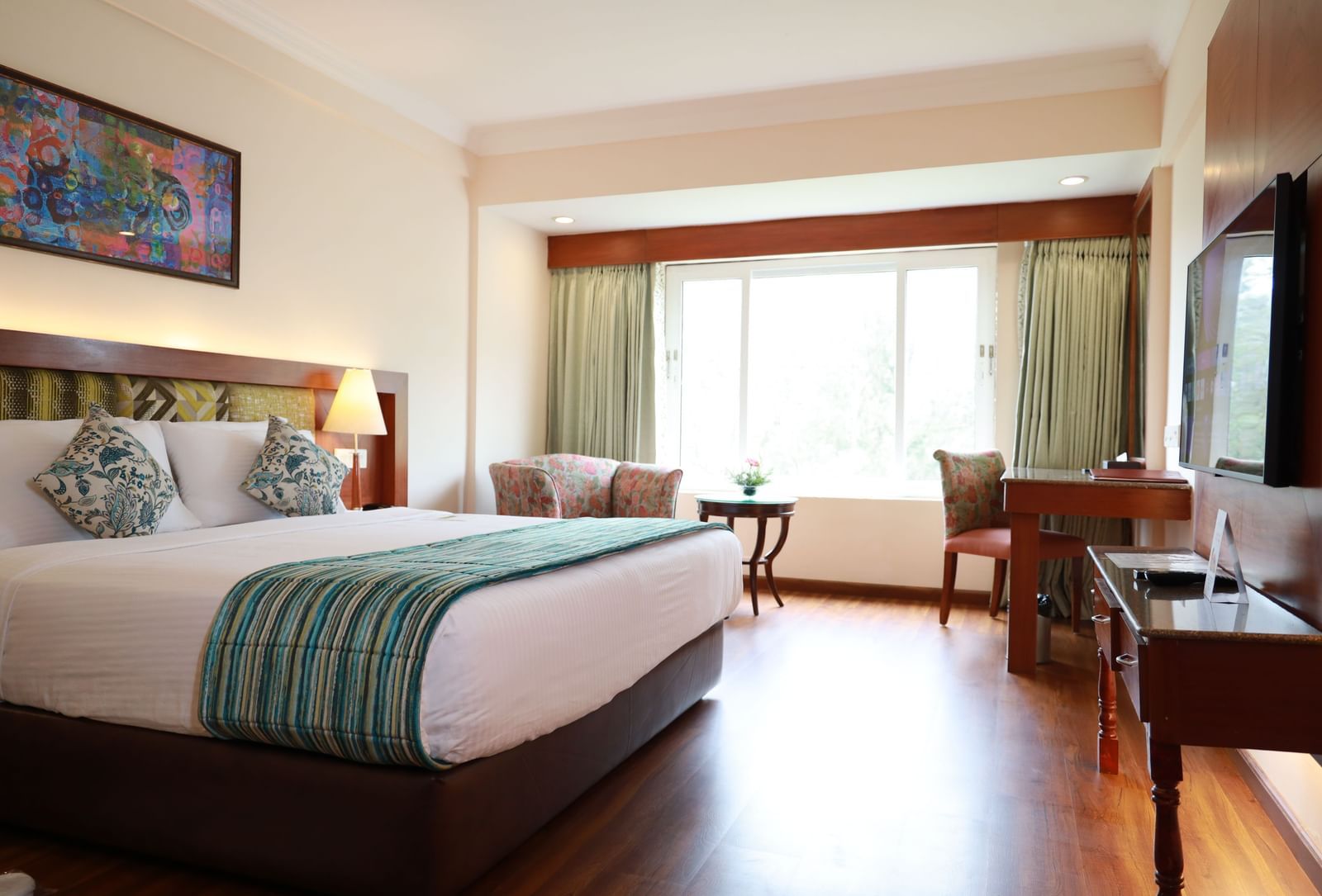 Superior Room at Accord Highland Ooty, featuring a plush bed, a bright window, and a work desk.