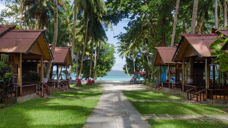 Pathway leading to beach with wooden cottages on either side