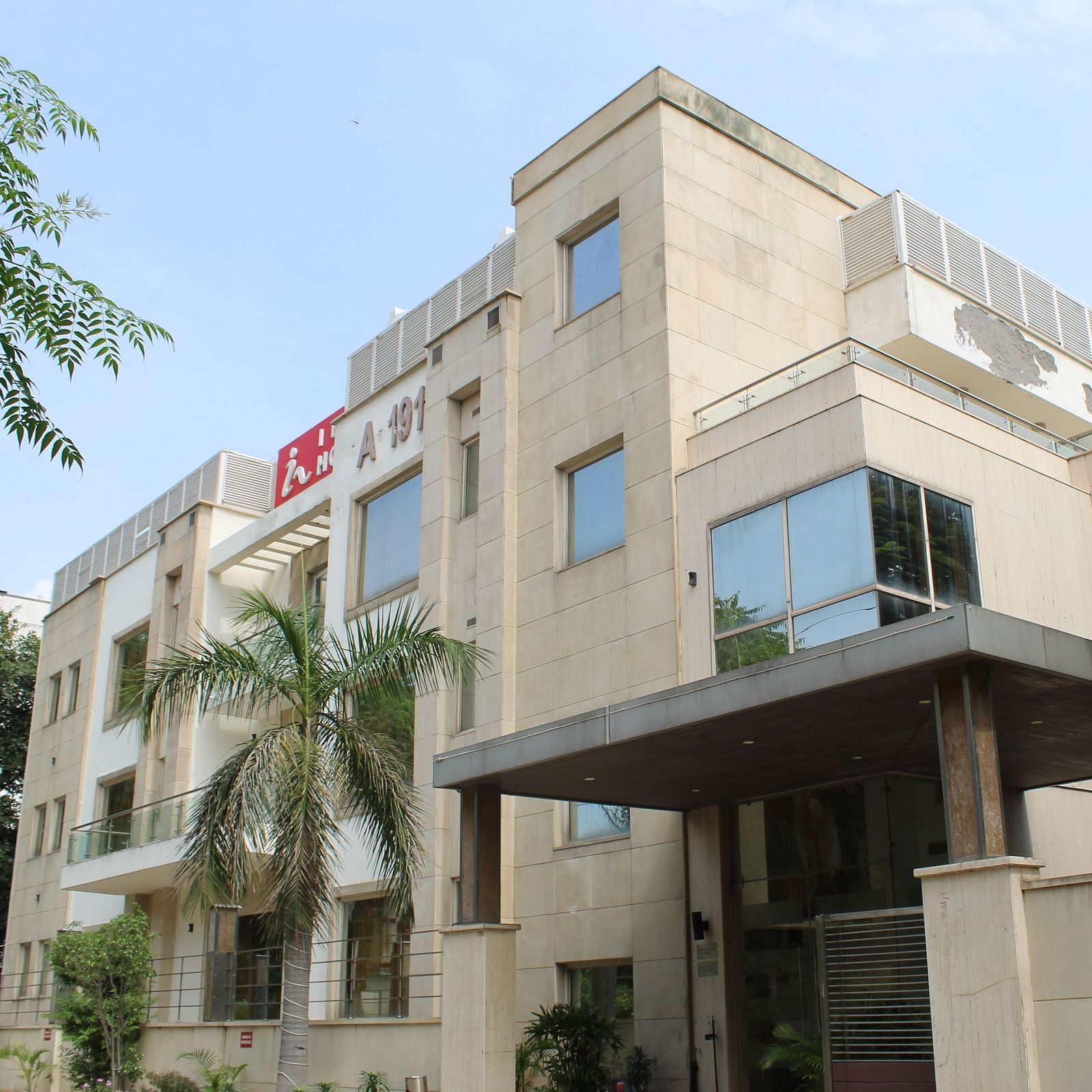 A facade image of Inde Hotels Vista Woods featuring a multi storey building surrounded by trees
