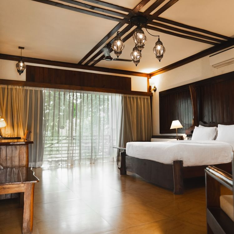 Premium Cottage Room featuring a bed, a table, and a window at Jagira Ananta Elite, Gir.