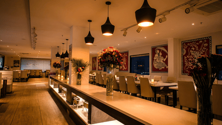 Evening view of the buffet counter with tall flower vases and candlelit tables at Tandoori Tamashaa restaurant, Ilara Hotels & Spa, Tada.
