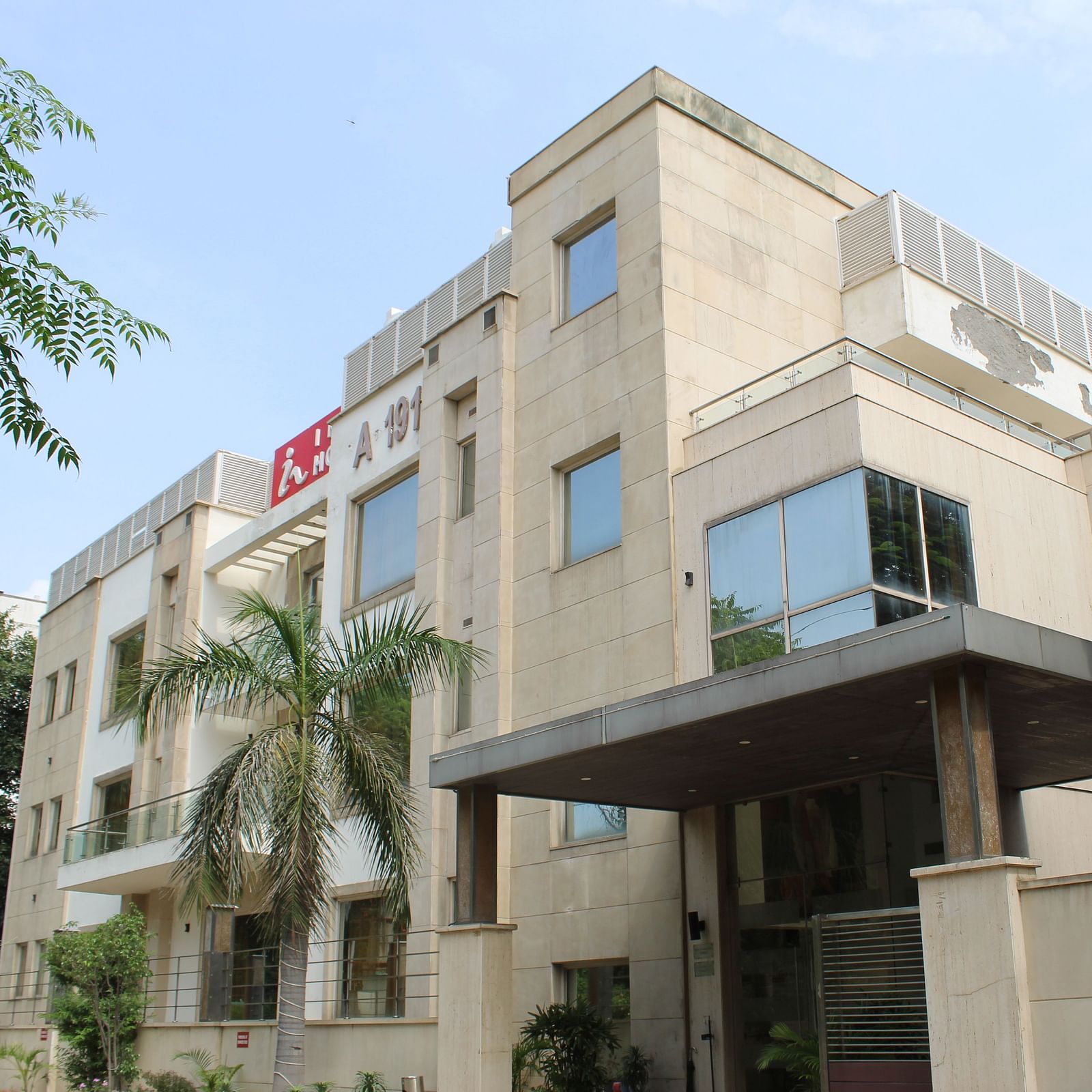 A facade image of Inde Hotels Vista Woods featuring a multi storey building surrounded by trees
