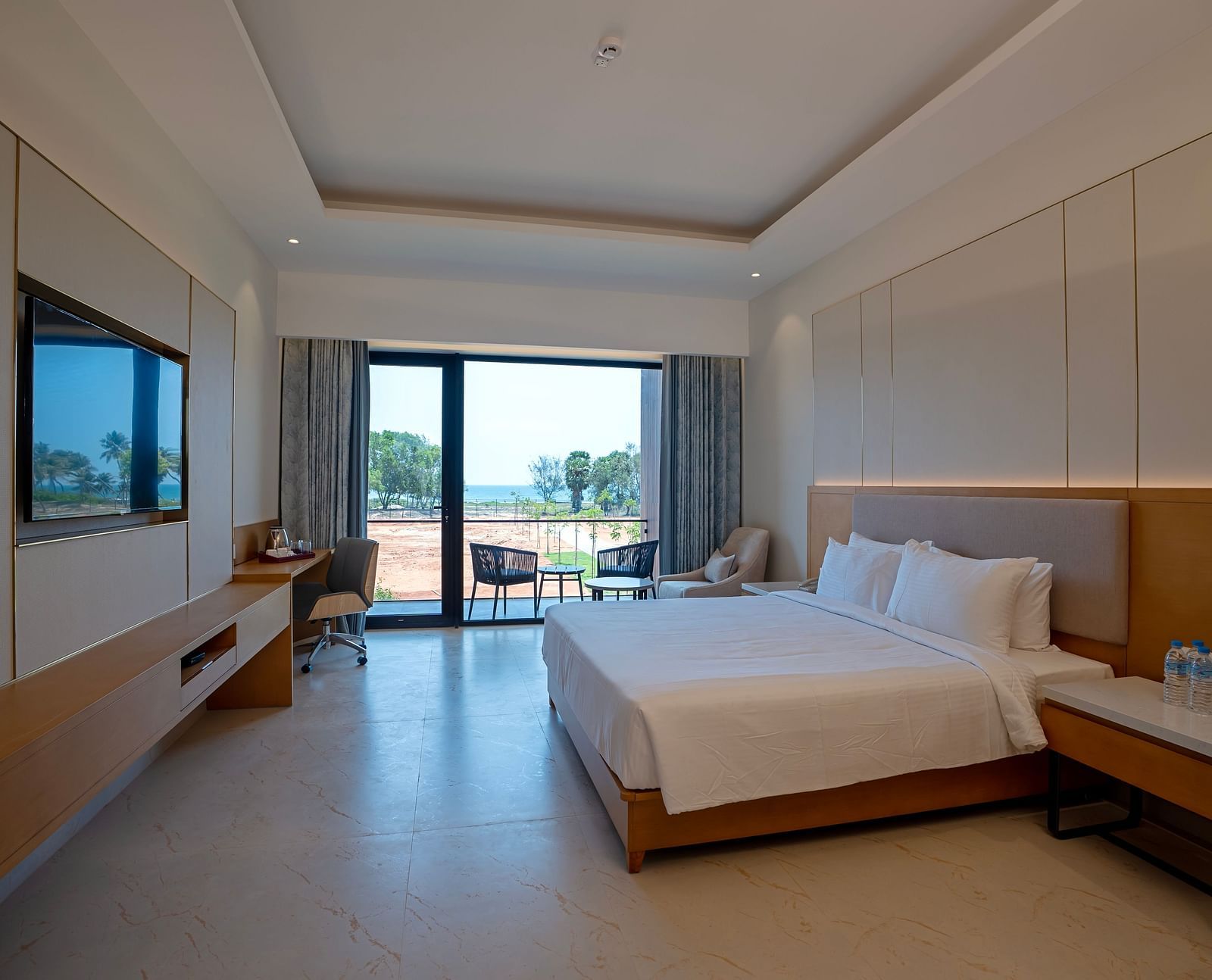A spacious room of the Bay View Bliss at The Shore, Trishvam with ample of natural light coming from the french windows.