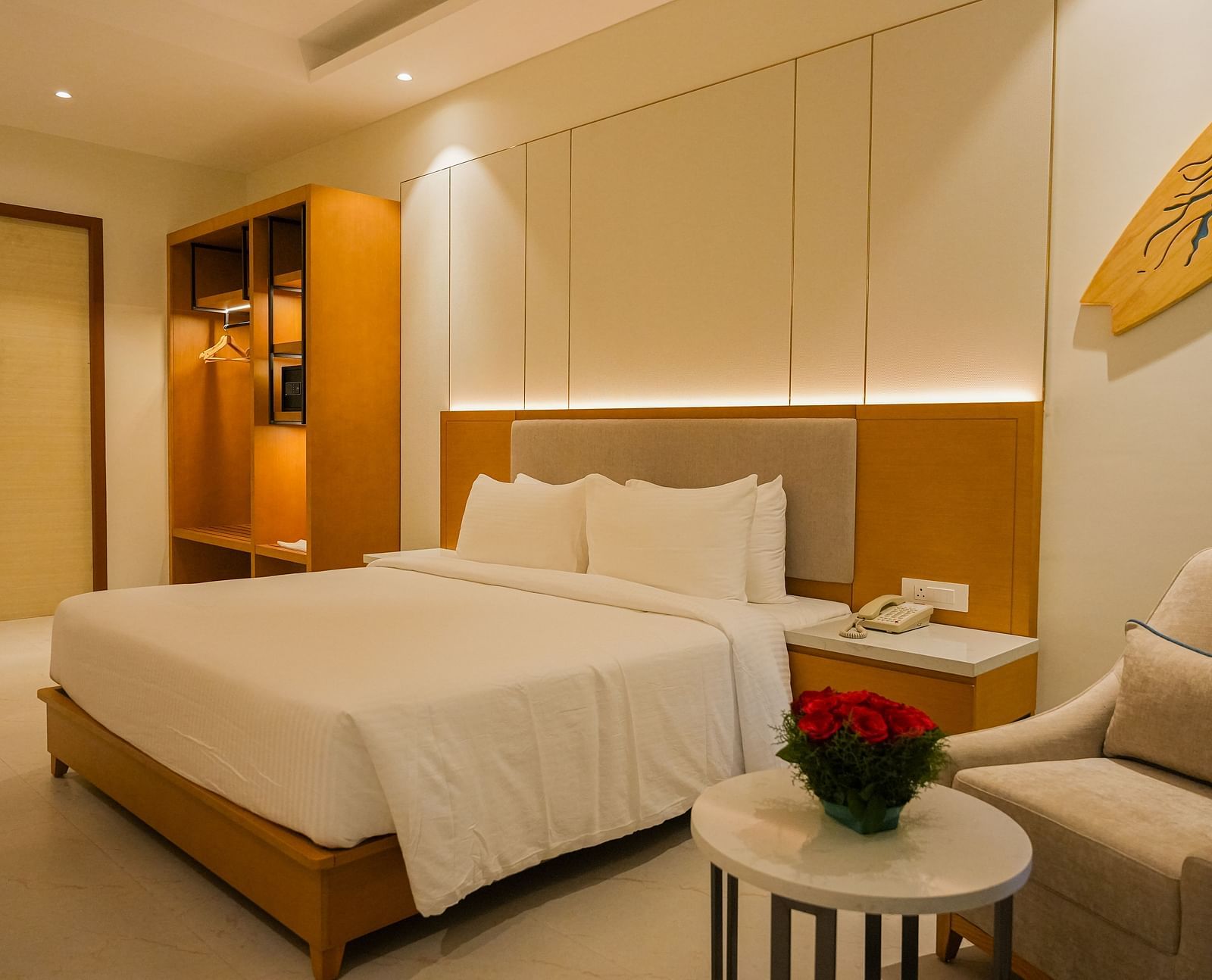 Elegant bedroom at The Shore Trishvam featuring a cosy king-size bed, warm wooden interiors, soft lighting, and modern amenities.