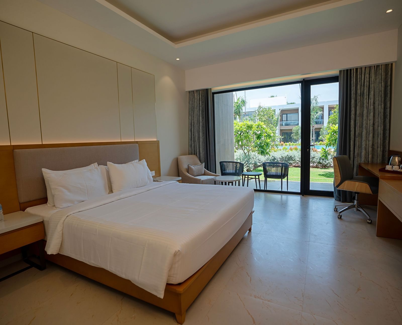 The Garden Courtyard room with huge french windows in the corner of the room at The Shore, Trishvam.